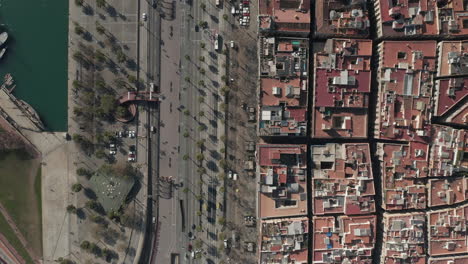 Top-down-panning-footage-of-wide-road-and-pedestrian-zone-at-Port-Vell-in-centre-of-city.-Barcelona,-Spain