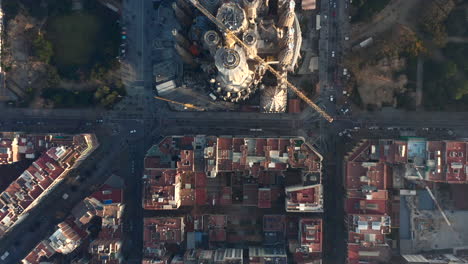 Fly-above-famous-basilica-Sagrada-Familia.-Top-down-footage-of-construction-site-of-unfinished-large-church.-Barcelona,-Spain