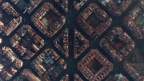 Top-down-panning-view-of-symmetrical-town-development-in-Eixample-district-at-golden-hour.-Barcelona,-Spain