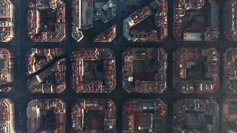 Town-development-arranged-into-square-blocks.-Birds-eye-shot-of-streets-and-buildings-at-golden-hour.-Barcelona,-Spain