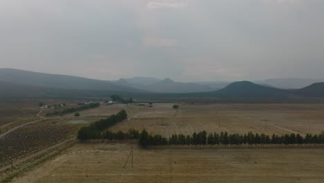 Control-Deslizante-De-Paisaje-Con-Granja-Y-Campos-Bajo-Cielo-Nublado.-Cordilleras-En-El-Fondo.-Sudáfrica