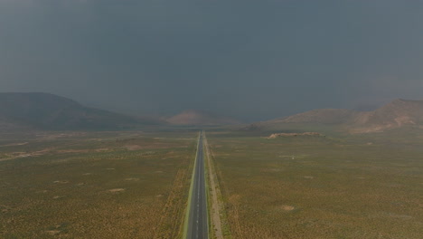 Aerial-footage-of-flat-landscape-between-mountains-on-sides.-Low-traffic-on-straight-road.-South-Africa