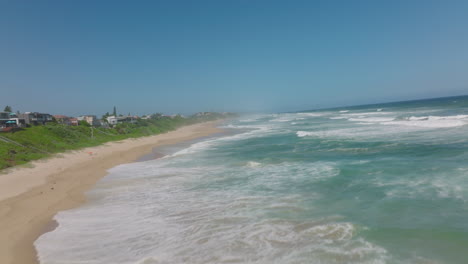 Tiefflug-über-Sandstrand.-Zunehmende-Enthüllung-Von-Wellen,-Die-Im-Urlaubsziel-An-Die-Küste-Rollen.-Südafrika