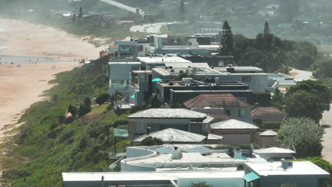 Aerial-footage-of-row-of-luxurious-residencies-or-guesthouses-along-sand-beach-on-sea-coast.-South-Africa