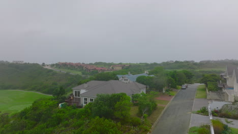 Fly-above-large-luxury-residences-surrounded-by-trees-and-shrubs.-Hazy-day-in-remote-urban-borough.-Port-Elisabeth,-South-Africa
