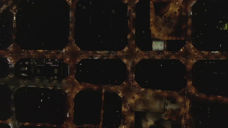 Overhead-view-of-illuminated-streets-in-city-from-height.-Night-traffic-in-urban-borough.-Barcelona,-Spain