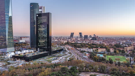 Backwards-reveal-of-modern-high-rise-buildings-in-business-district.-Aerial-hyperlapse-footage-at-dusk.-Madrid,-Spain