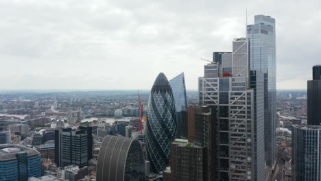 Forwards-fly-above-downtown.-Heading-towards-City-skyscrapers.-Iconic-round-shaped-building-with-twisted-pattern-looks-like-gherkin.-London,-UK