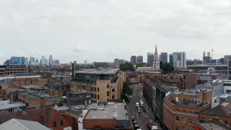 Aerial-panoramic-view-of-urban-neighbourhood.-Descending-footage-with-modern-skyscrapers-in-background.-London,-UK