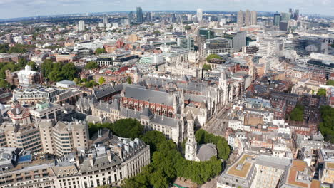 Forwards-fly-above-old-buildings-along-Strand-street.-Historic-Royal-Courts-of-Justice-buildings-complex.-London,-UK