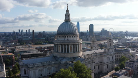 Slide-and-pan-footage-of-Saint-Pauls-Cathedral-against-bright-clouds-in-sky.-Tall-building-on-opposite-bank-of-River-Thames-making-parallax-effect.-London,-UK