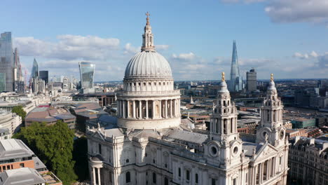Fly-around-Saint-Pauls-Cathedral-on-Ludgate-Hill.-Tall-modern-buildings-with-glossy-glass-facades-in-background.-London,-UK