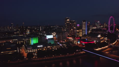 Slide-and-pan-footage-of-colourful-buildings-on-Thames-river-south-bank.-National-Theatre,-round-white-shining-cinema-building-and-Royal-Festival-Hall.-London,-UK