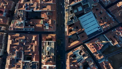 Aerial-birds-eye-overhead-top-down-panning-shot-of-blocks-of-buildings-in-town.-Tracking-of-vehicles-driving-in-streets.