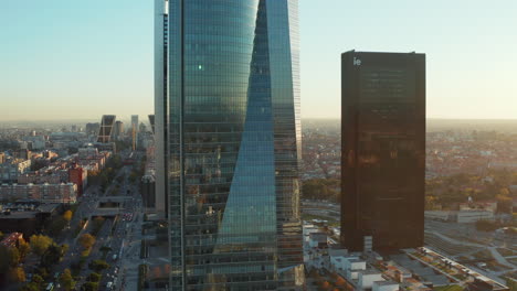 Slide-and-pan-footage-of-modern-buildings-in-Cuatro-Torres-Business-Area.-Glossy-glass-facades-of-skyscrapers-reflecting-surroundings.