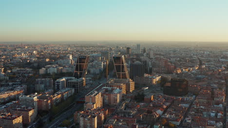 Slide-and-pan-shot-of-Puerta-de-Europa-modern-business-towers.-Fly-above-city-at-sunset.