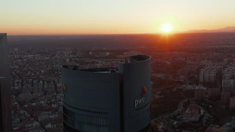 Fliegen-Sie-Um-Die-Spitze-Des-Pwc-Towers-Im-Geschäftsviertel-Cuatro-Torres-Herum.-Modernes-Bürohochhaus.-Blick-Gegen-Die-Untergehende-Sonne.