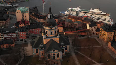 Aerial-tilt-down-footage-of-Church-of-Catherine.-Cruise-ship-on-water-surface-in-background.-Stockholm,-Sweden