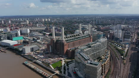 Slide-and-pan-footage-of-Battersea-Power-Station-complex.-Historical-coal-burning-power-station-with-four-chimneys-on-bank-of-Thames-river.-London,-UK