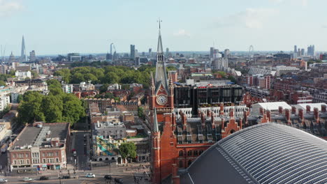 Slide-and-pan-footage-of-historic-red-brick-building-with-clock-tower.-St-Pancras-train-station-and-panoramic-aerial-view-of-city.-London,-UK