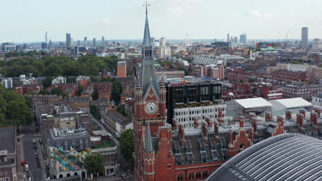 Fly-around-clock-tower.-Historic-building-of-St-Pancras-train-station-in-Camden-borough.-Aerial-panoramic-view-of-city.-London,-UK