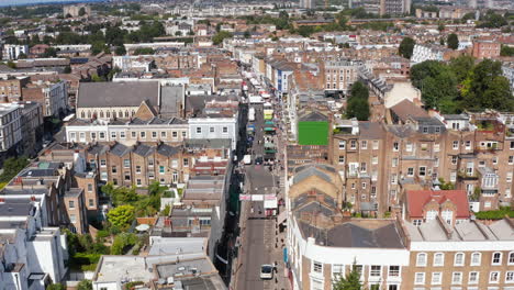 Forwards-descending-fly-to-street-market-on-Portobello-Road.-Aerial-view-of-urban-borough.-London,-UK