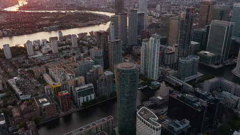 Imágenes-Inclinadas-Y-Panorámicas-Del-Moderno-Distrito-De-Negocios-Con-Edificios-Futuristas-Alrededor-Del-Canal-De-Agua.-Vista-Aérea-De-Canary-Wharf-Al-Atardecer.-Londres,-Reino-Unido