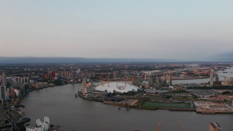 Aerial-view-of-Millennium-Dome-on-Greenwich-Peninsula.-The-O2-entertaining-district-on-Thames-riverbank-in-sunset-time.-London,-UK