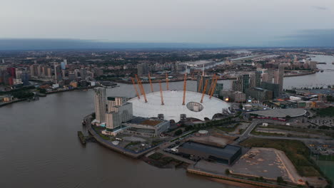 Aerial-view-of-futuristic-Millennium-Dome.-River-Thames-calmly-flowing-around-The-O2-entertaining-district.-London,-UK