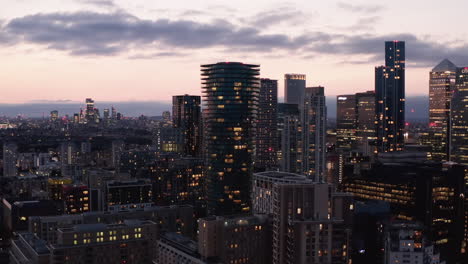 Panorama-curve-shot-of-modern-business-urban-district-with-tall-skyscrapers-in-blue-hour.-Cityscape-against-pink-twilight-sky.-London,-UK