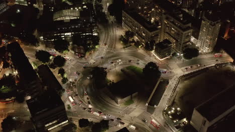 Night-aerial-footage-of-traffic-at-Elephant-and-Castle.-High-angle-view-of-vehicles-driving-through-abnormal-round-shaped-crossroad.-London,-UK