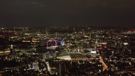 Aerial-panoramic-view-of-city-at-night.-Waterloo-train-station-and-London-Eye-tourist-attraction.-London,-UK