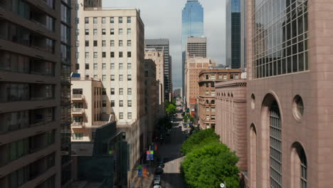 Forwards-reveal-of-buildings-along-downtown-street.-Fly-between-various-buildings.-Dallas,-Texas,-US