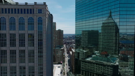 Die-Glänzende-Glasfassade-Des-John-Hancock-Tower-Spiegelt-Die-Umliegenden-Gebäude-Wider.-Vorwärts-Fliegen-über-Der-Stadt.-Boston,-USA