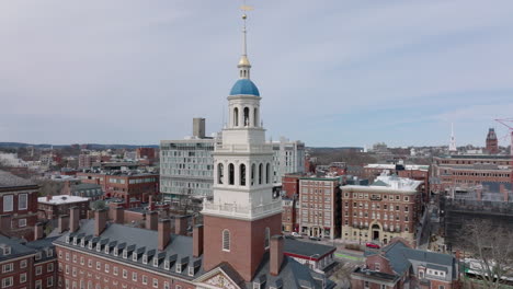Orbit-shot-around-building-with-tall-tower.-Aerial-view-of-historic-brick-houses-of-Harvard-University.-Boston,-USA