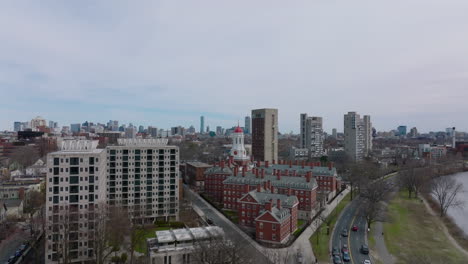 Fly-over-historic-buildings-of-Dunster-House,-part-of-famous-Harvard-University.-Revealing-cityscape-from-height.-Boston,-USA