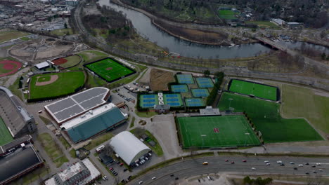 Sport-area-for-various-disciplines.-Aerial-view-of-university-sports-centre.-Cars-driving-on-busy-multilane-road.-Boston,-USA