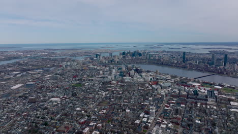 Amazing-cinematic-aerial-panoramic-footage-of-metropolis-on-sea-side.-Backwards-reveal-of-buildings-in-residential-borough,-downtown-skyscrapers-and-islands-in-background.-Boston,-USA