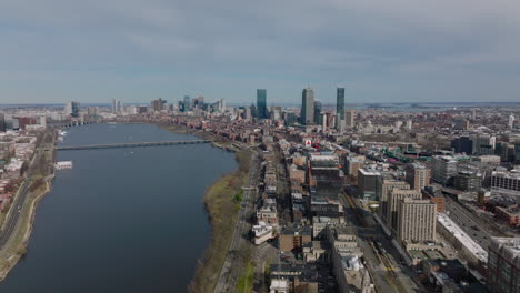 Aerial-panoramic-view-of-large-city.-Wide-river-at-water-dam-and-downtown-skyscrapers-in-distance.-Boston,-USA