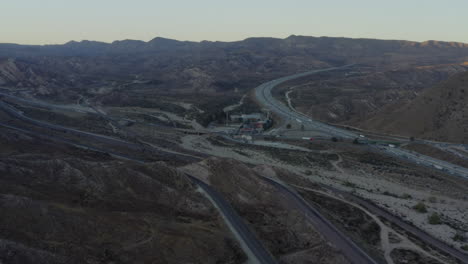 AERIAL:-Over-Highway-in-California-Countryside-with-Mountains-at-Sunset