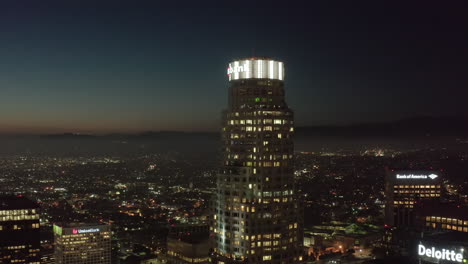 Famoso-Rascacielos-Us-Bank-Tower-Of-Los-Angeles-Skyline-Con-Vista-En-La-Azotea-Sobre-La-Ciudad-Por-La-Noche,-Dron-Aéreo-Estableciendo-Una-Toma-Amplia,-Alrededor-De-2019