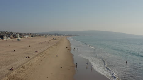 AERIAL:-People-at-the-Beach-Waves,Water-in-Los-Angeles,-California,-Sunny,-Blue-Sky