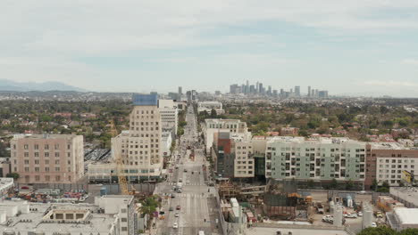 Antena:-Vuelo-Sobre-El-Bulevar-Wilshire-Hacia-El-Centro-De-Los-Angeles,-California-Con-Obras-En-Primer-Plano-En-Un-Día-Nublado