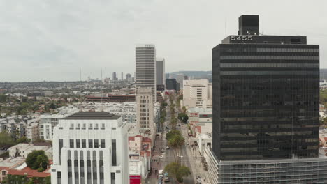 Antenne:-Flug-über-Den-Wilshire-Boulevard-In-Der-Nähe-Von-Straßen-Und-Gebäuden-Mit-Autoverkehr-In-Los-Angeles,-Kalifornien-An-Einem-Bewölkten-Tag