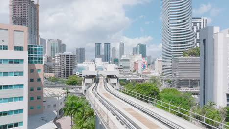 Fly-over-Metromover-track-leading-on-columns-above-park.-Modern-passenger-transport-vehicle-in-metropolis.-Miami,-USA