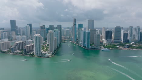 Aerial-view-of-boats-moving-on-water-surface-around-high-rise-buildings-in-modern-city-borough.-Miami,-USA