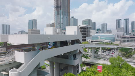 Automatic-system-for-passenger-transport-in-city.-Metromover-rail-car-leaving-station-elevated-high-above-ground.-Miami,-USA