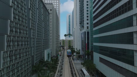 Metromover-automatic-passenger-transport-cars-passing-by-each-other-on-tracks-in-modern-luxurious-borough.-Miami,-USA