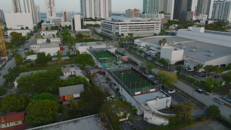 Small-football-playfield-in-city-in-tropics.-Players-having-match-in-fenced-area-in-modern-town.-Miami,-USA