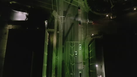 AERIAL:-Lookup-over-Wilshire-Boulevard-Street-in-Hollywood-Los-Angeles-at-Night-with-View-on-Streets-and-City-Car-Traffic-Lights